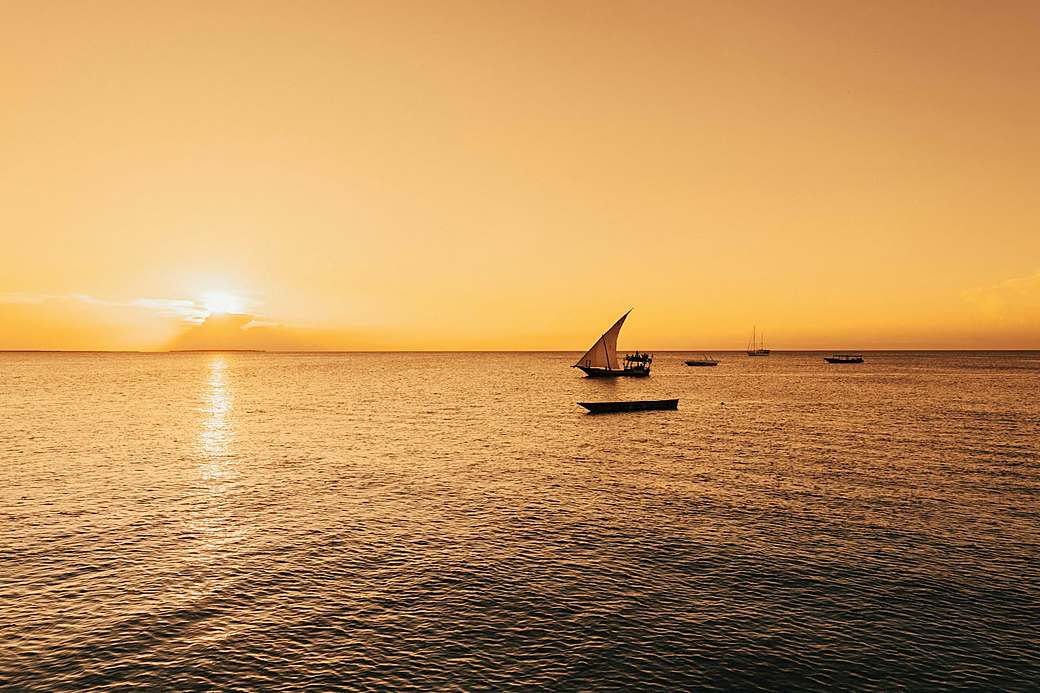 A dhow sailing at sunset off Zanzibar